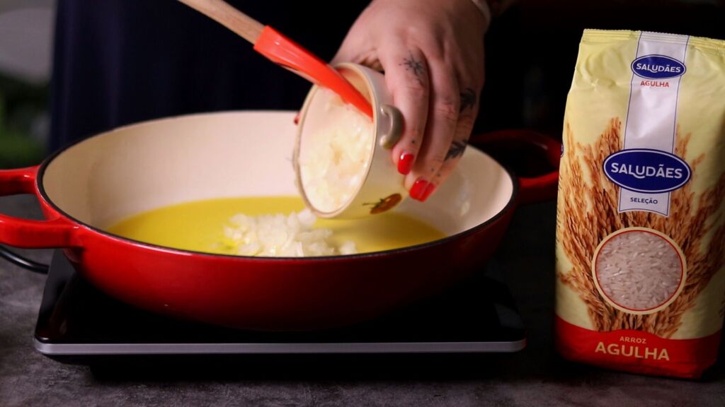 refogue a cebola picada com o azeite, junte os dentes de alho e deixe que aromatizem o azeite