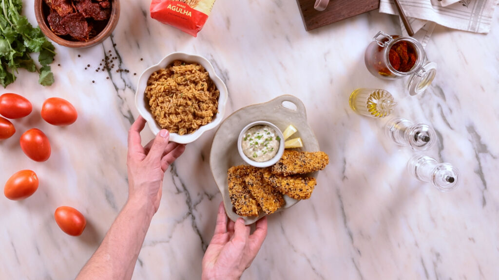 Use uma combinação de farinha temperada, ovos batidos e uma mistura de cornflakes triturados com sementes de sésamo