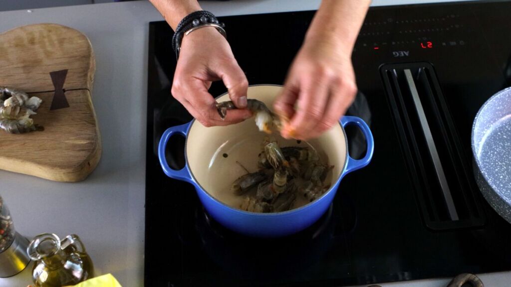 Descasque os camarões e prepare um caldo aromático