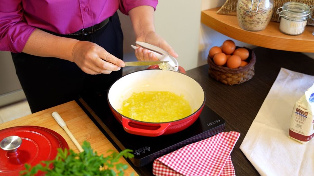 Comece por colocar a cebola e alho picado num tacho com azeite e deixe alourar