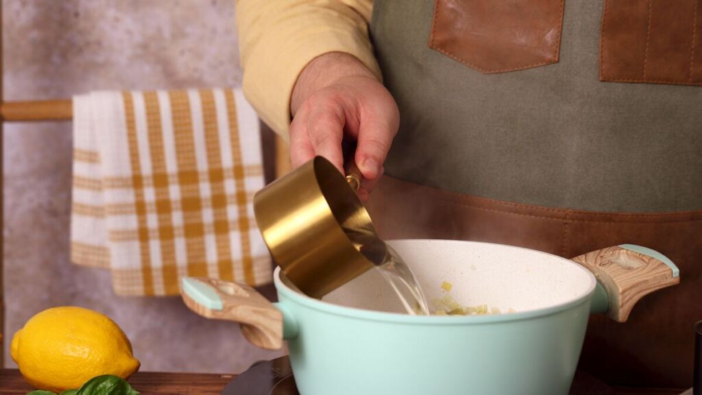 Reduza o lume para médio-baixo e mexa ocasionalmente, permitindo que o arroz absorva todo o caldo antes de adicionar mais líquido.