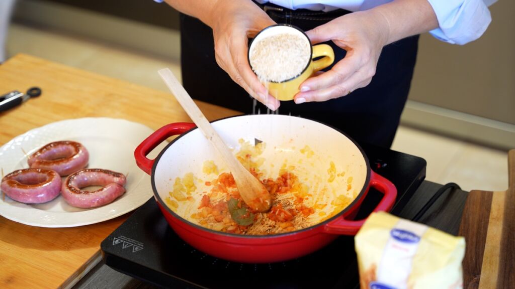 Incorpore o arroz ao refogado e deixe-o fritar durante dois minutos para permitir que os grãos fiquem bem envolvidos nos sabores.