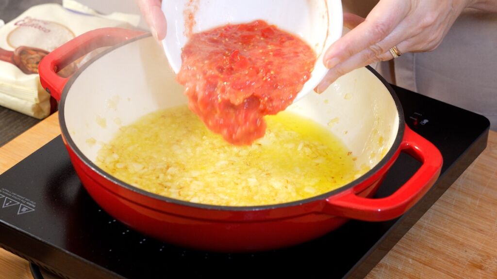 Num tacho, coloque o azeite, a cebola e o alho para refogar.