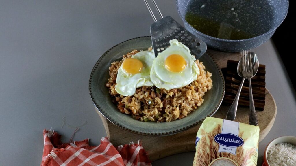 A apresentação do ovo sobre o arroz com feijão bem temperado cria um contraste visual e de sabores irresistíveis.