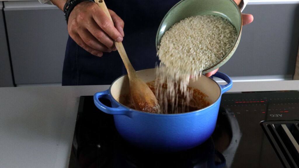 Adicione o arroz e o caldo, mexa e deixe cozer em lume brando durante 12 minutos.