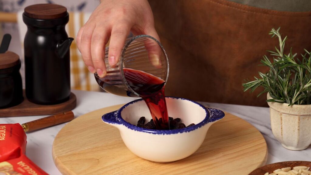 Numa tigela, coloque as passas e o vinho do Porto e deixe hidratar no mínimo 1 hora ou durante a noite.