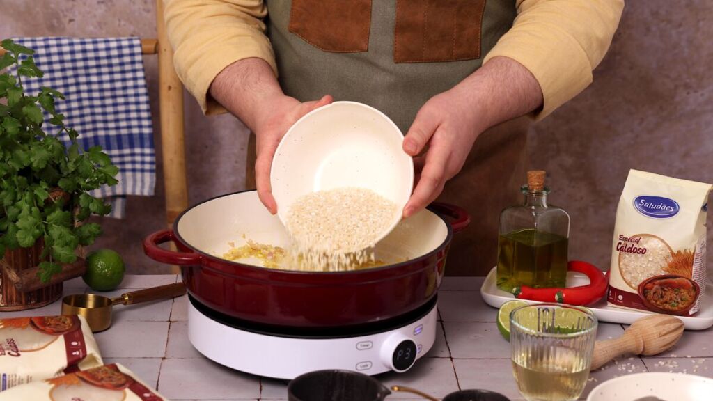 Adicione os 200g de arroz especial caldoso Saludães e mexa, deixando-o fritar um pouco. Este passo é essencial para que o arroz mantenha a sua estrutura durante o cozimento e absorva melhor os sabores